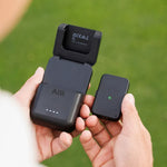 Arccos Air and Charging device being held by a golfer with a golf course background