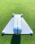 Golfer's eye-line view down the Flight Deck Putting Tour Kit mirrored surface with a golf ball centred on the alignment line and two tee pegs visible at the top