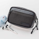 Fourteen Golf black round pouch displayed on white surface alongside two branded white golf tees and two golf balls, showing dual zipper pulls and front pocket