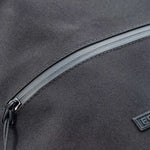 Macro detail of Fourteen Golf shoe bag showing curved front zip pocket seam with PU leather piping, ballistic nylon fabric texture, and gunmetal zipper pull
