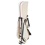 Fourteen Golf stand bag in cream and burgundy colorway with legs retracted, showing dual burgundy stand legs, black hardware, FOURTEEN wordmark, front zip pocket, and dual shoulder strap system on white background