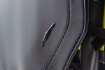 Close-up detail of Fourteen Golf stand bag showing embossed feather logo on matte grey PU leather body alongside perforated leather panel and neon yellow piping accent