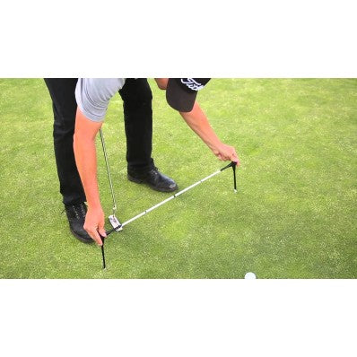 Man using the adjustable alignment sticks on the green