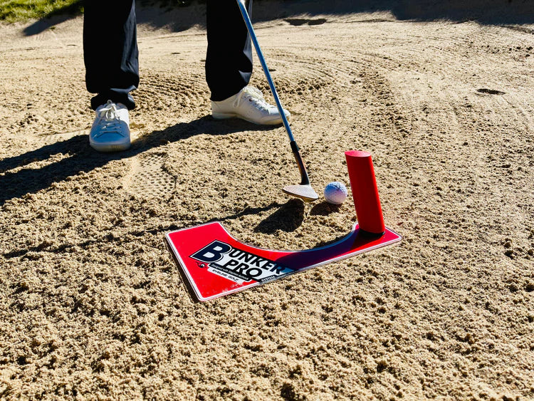 Wedge address position behind a golf ball set up on the EyeLine Golf Bunker Pro System board with entry peg in position in a bunker