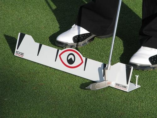 Golfer addressing the ball using the EyeLine Golf Edge Putting Rail to train a square putter path and consistent stroke arc