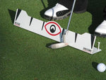 Ground-level view of a putter swinging through the EyeLine Golf Edge Putting Rail gate with golf ball positioned at the tee peg