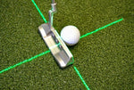 Low-angle view of putter head and golf ball positioned at the intersection of the EyeLine Golf Groove Putting Laser cross beam on a putting green