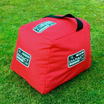 A red Eyeline Golf Impact Cube placed on grass, designed as a golf training aid with multiple angles for swing practice.