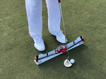 Golfer at address with putter and ball at the EyeLine Golf Edge Putting Rail with Memory Band, showing proper foot position on either side of the rail