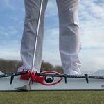 A golfer using the Eyeline Golf Memory Band System for putting rail training. The system is placed on the ground, and the golfer is pressing against it with a putter.