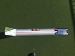 Overhead view of the EyeLine Golf Sight Line putting training aid laid flat on the green, showing the red alignment stripe and attached putting mirror