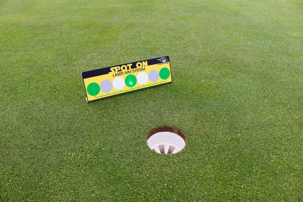 EyeLine Golf Spot On Laser Aim System target placed just behind the hole on the green, showing the green and white dot target face used to receive the laser beam