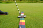 Side-angle view of putter positioned on the EyeLine Golf Stroke Meter by Todd Sones, with colour-coded backstroke and follow-through zones visible along the full length of the mat