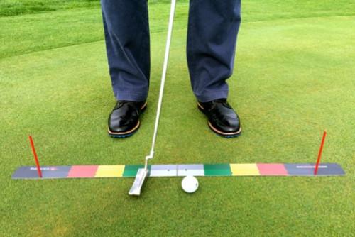 Front-facing view of golfer at address over the EyeLine Golf Stroke Meter on the green, putter centred on the colour-coded mat