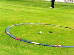 Large orange and black Eyeline Golf Target Circle laid around a flagstick on the green, with a golf ball positioned inside for proximity-to-hole putting drills