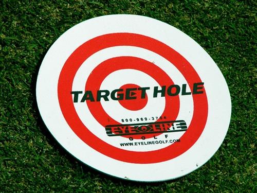 Eyeline Golf Target Hole disc laid flat on grass showing full bullseye design, used as a visual target for short game practice drills
