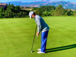 Golfer using the Eyeline Golf Putting Pendulum Rod alongside a putter at address on a scenic mountain course green