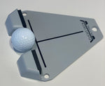 Angled side view of the Flight Deck Putting Tour trainer on a white surface with a golf ball seated in the single-sided impact block gate