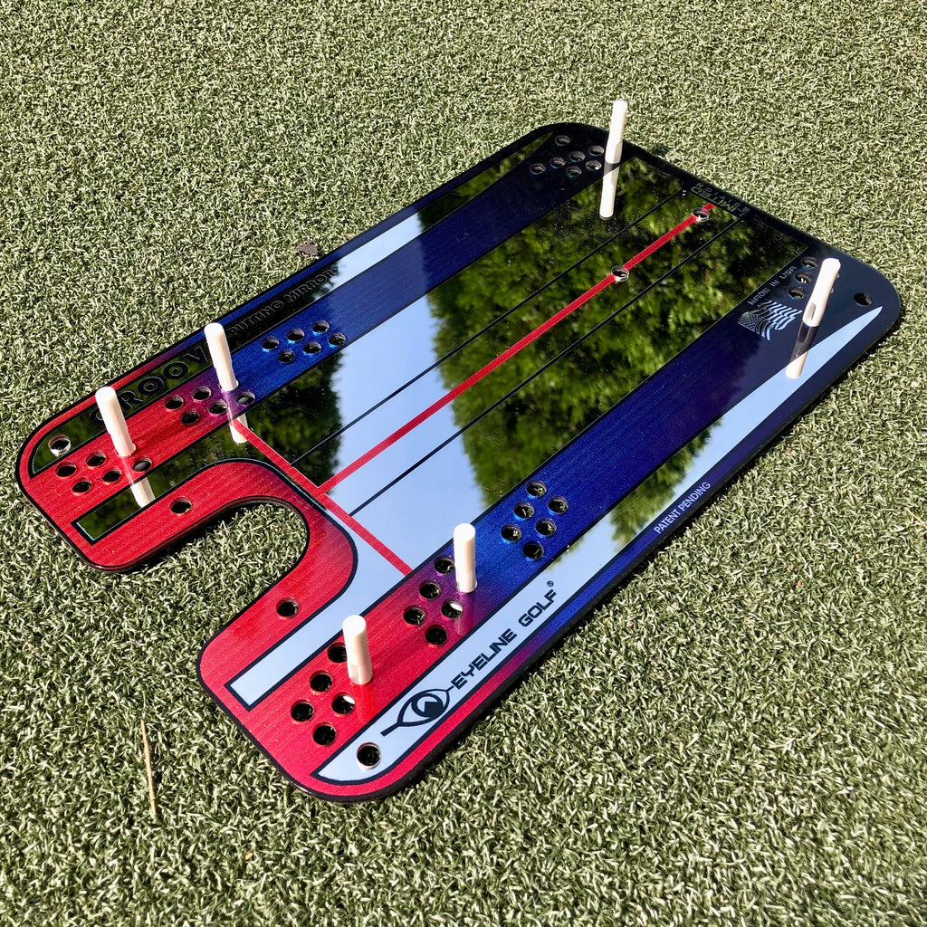 A Groove putting mirror with red and blue colors, designed for golf training, placed on a green surface.